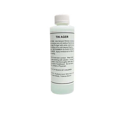 A bottle labeled 'TIN AGER' with instructions for use on metal surfaces.